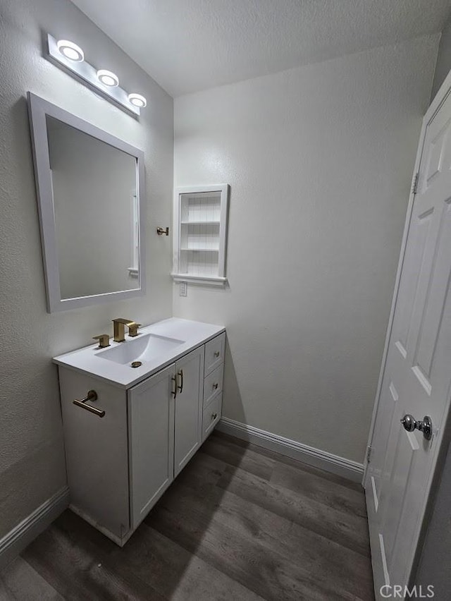 bathroom featuring vanity, wood-type flooring, and a textured ceiling