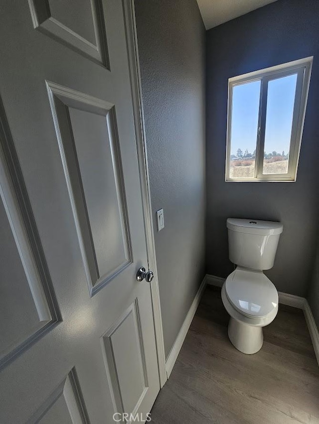 bathroom featuring hardwood / wood-style flooring and toilet