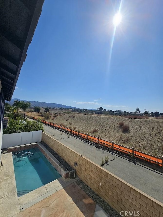 view of swimming pool featuring a rural view