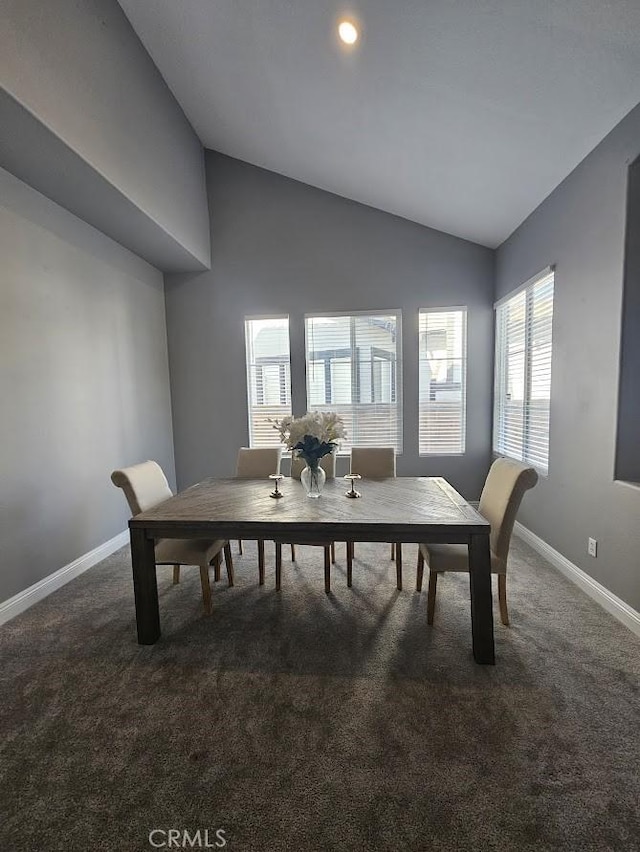 carpeted dining space featuring lofted ceiling