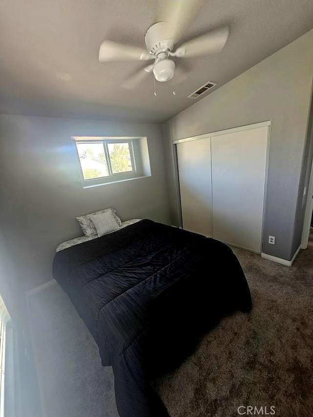 carpeted bedroom with a closet, ceiling fan, and lofted ceiling