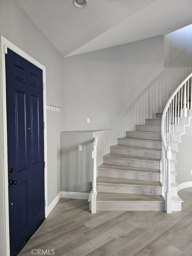 entrance foyer featuring wood-type flooring and a textured ceiling