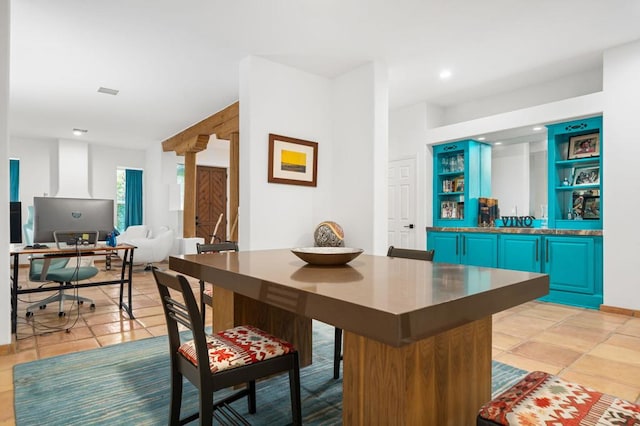 bar featuring blue cabinets and light tile patterned floors