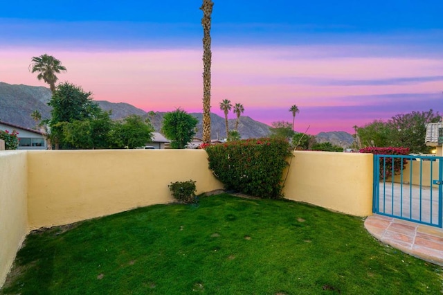 yard at dusk featuring a mountain view