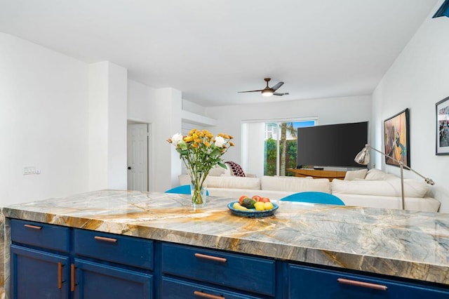 kitchen featuring butcher block countertops, blue cabinetry, and ceiling fan