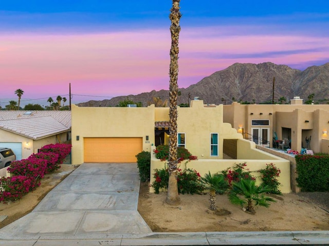 adobe home with a garage and a mountain view