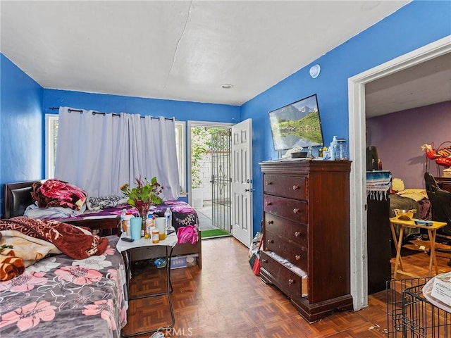 bedroom featuring access to exterior and parquet flooring