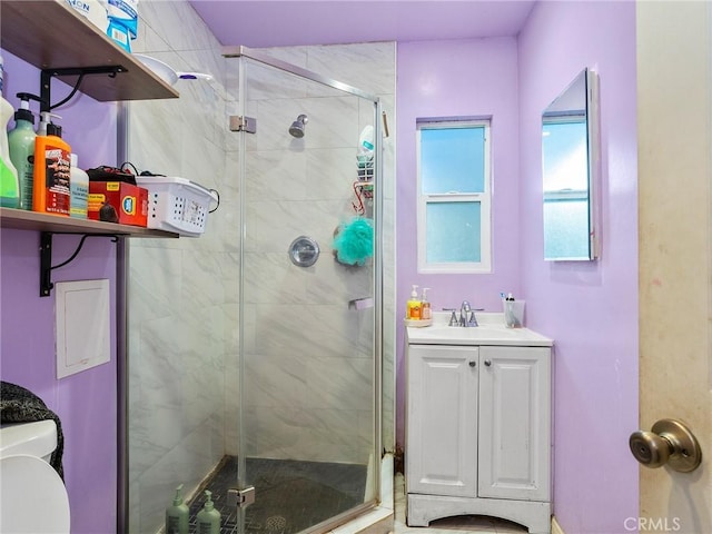 bathroom featuring vanity, toilet, and a shower with shower door