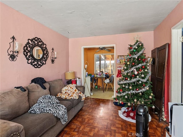 living room with ceiling fan and dark parquet flooring