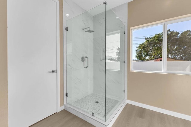 bathroom with hardwood / wood-style floors and an enclosed shower