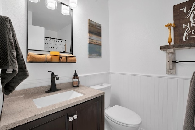 bathroom featuring a shower with shower curtain, vanity, and toilet