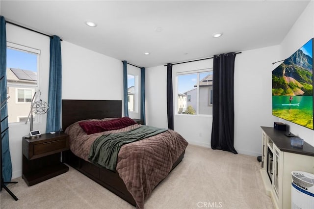 bedroom with light carpet and multiple windows