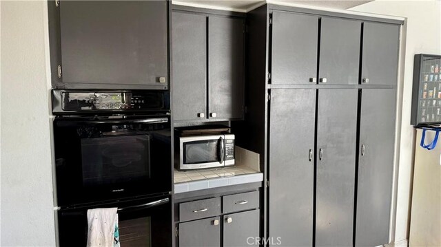 7002 Valentine Dr, Huntington Beach, CA 92647 - kitchen featuring stainless steel microwave, tile counters, gray cabinets, and dobule oven black