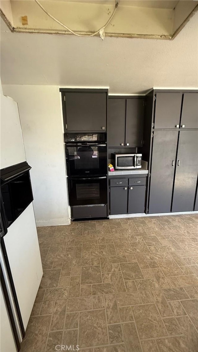 7002 Valentine Dr, Huntington Beach, CA 92647 - kitchen with stainless steel microwave, gray cabinetry, and dobule oven black