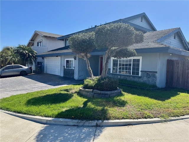 traditional home featuring a garage, concrete driveway, a front yard, and fence