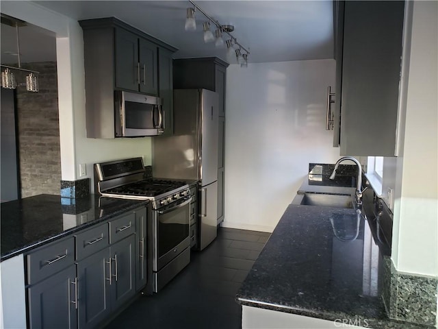 kitchen with dark stone counters, gray cabinetry, sink, and stainless steel appliances