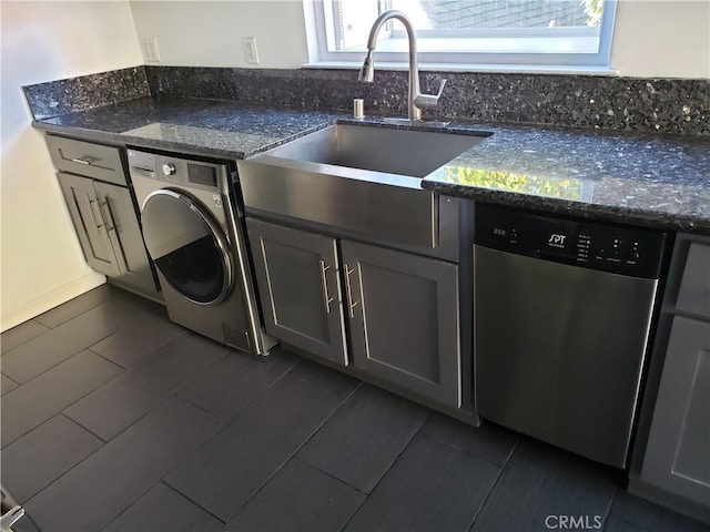 laundry room featuring washer / dryer, dark tile patterned flooring, and sink