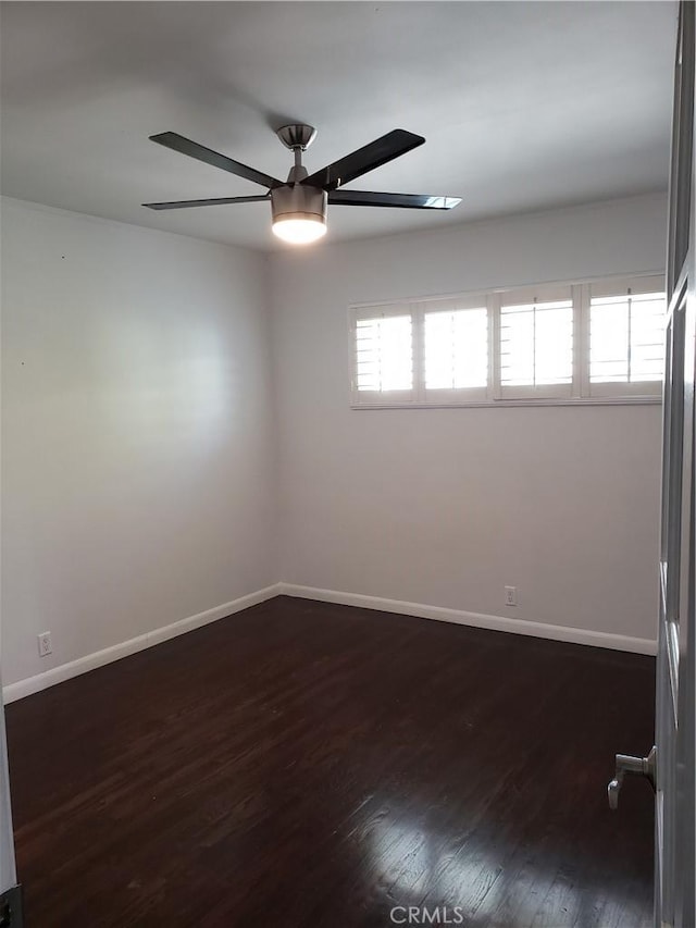 spare room with a wealth of natural light, dark wood-type flooring, and ceiling fan