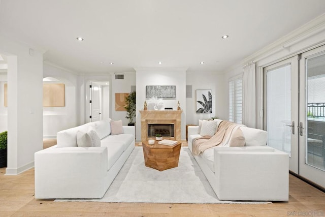 living room with french doors, light hardwood / wood-style floors, and ornamental molding