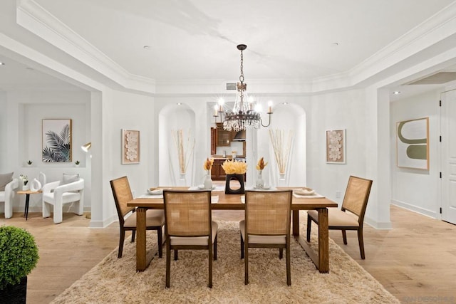 dining room with light hardwood / wood-style flooring, a notable chandelier, and ornamental molding