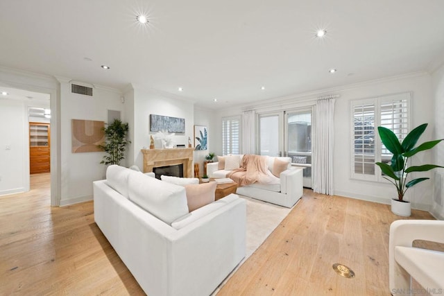 living room with light wood-type flooring and ornamental molding