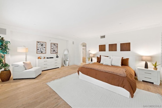 bedroom with light hardwood / wood-style floors and ornamental molding