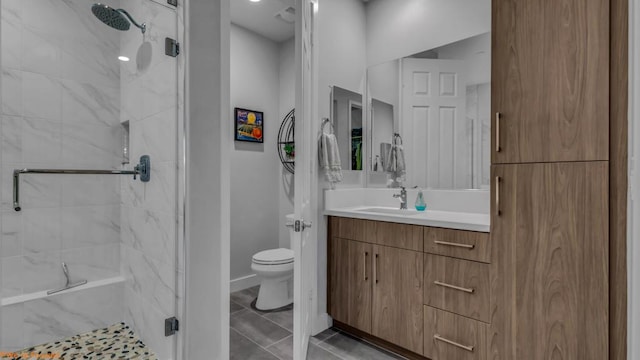 bathroom featuring tile patterned floors, vanity, toilet, and an enclosed shower