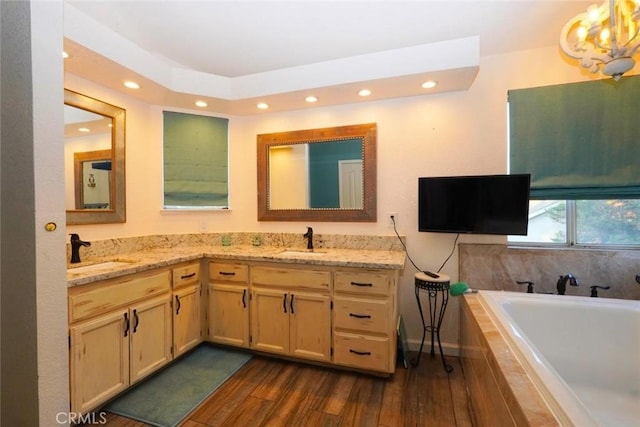 bathroom featuring hardwood / wood-style floors, vanity, and tiled bath