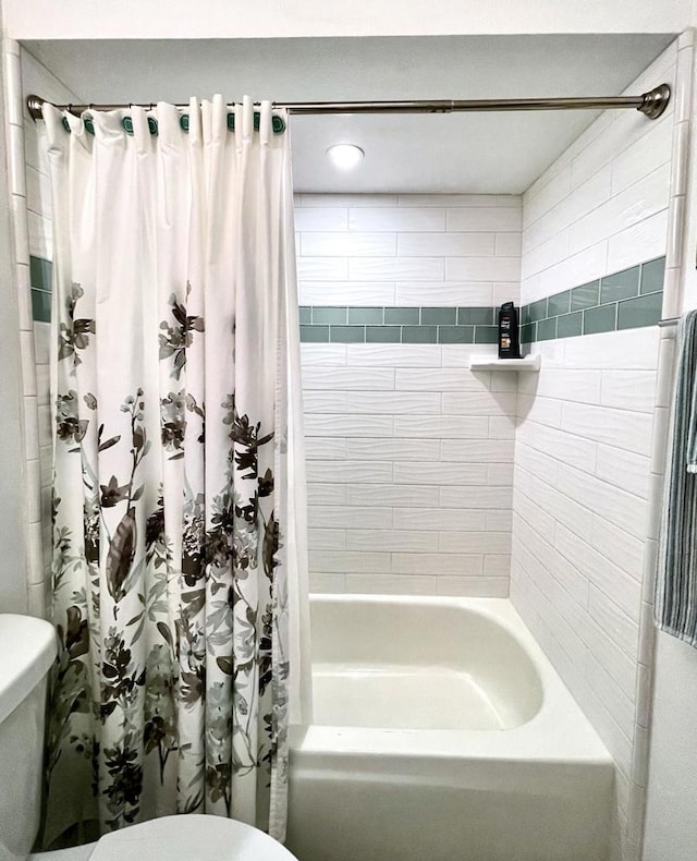 bathroom featuring toilet and shower / tub combo with curtain