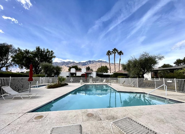 view of swimming pool featuring a mountain view and a patio