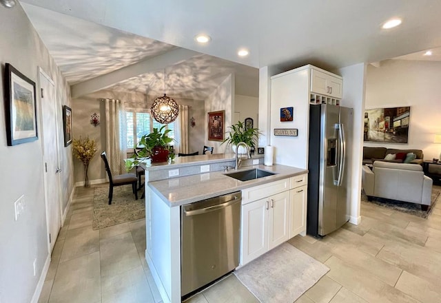 kitchen with light stone countertops, white cabinets, appliances with stainless steel finishes, sink, and a notable chandelier