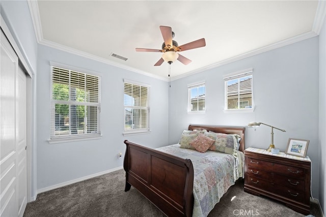 bedroom with multiple windows, ceiling fan, a closet, and dark colored carpet