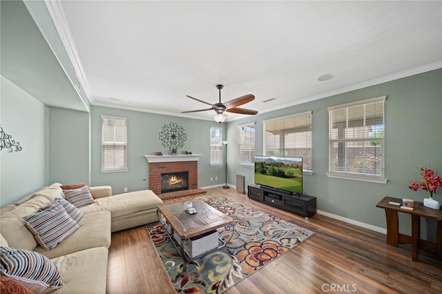 living room with ceiling fan, dark hardwood / wood-style flooring, ornamental molding, and a fireplace