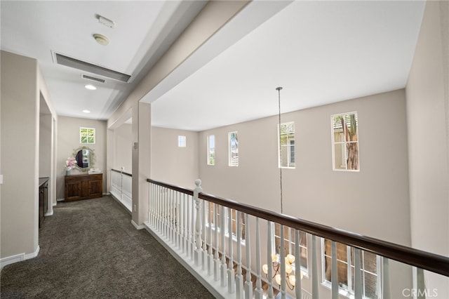 hallway with dark colored carpet