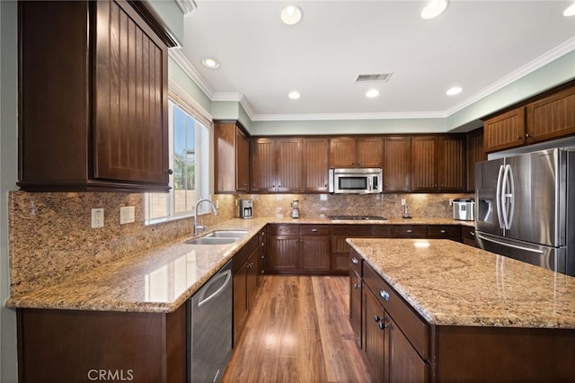 kitchen featuring light stone counters, ornamental molding, and appliances with stainless steel finishes