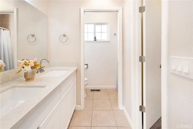 bathroom with tile patterned floors, vanity, and toilet