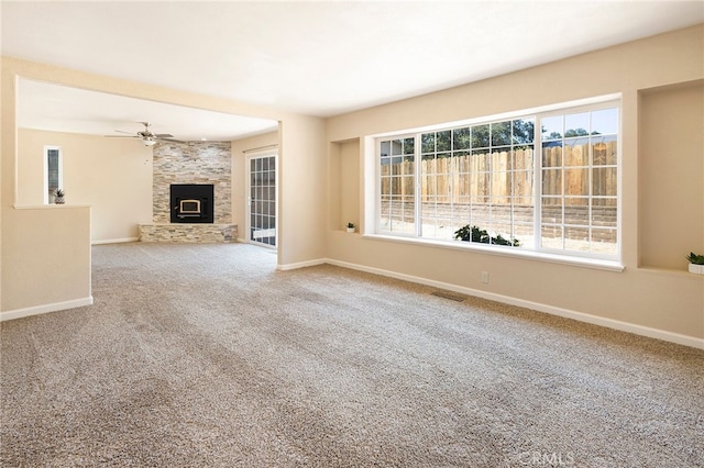 unfurnished living room featuring ceiling fan, carpet flooring, and a fireplace