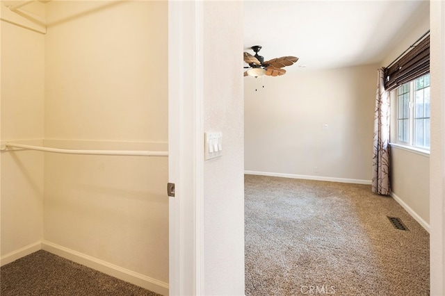 interior space with ceiling fan and carpet