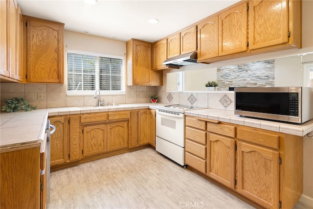 kitchen with tile counters, tasteful backsplash, and electric range