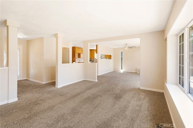 carpeted spare room featuring ceiling fan and ornate columns