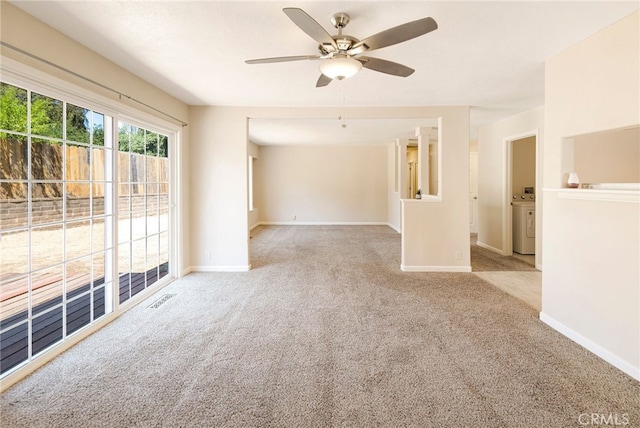 carpeted empty room with ceiling fan and washer / dryer