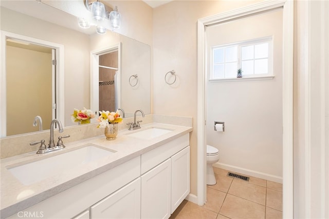 bathroom featuring toilet, vanity, and tile patterned flooring