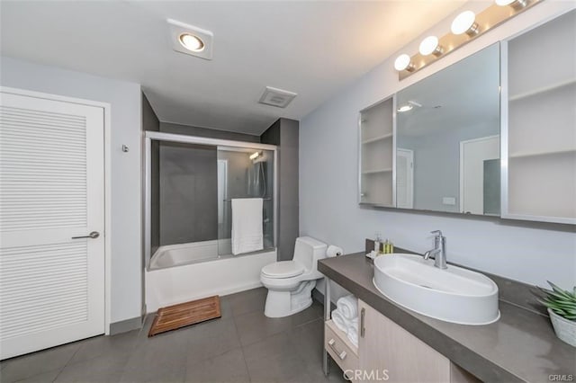 full bathroom with shower / bath combination with glass door, vanity, tile patterned flooring, and toilet