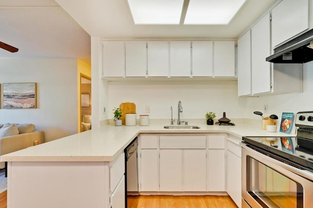 kitchen with appliances with stainless steel finishes, white cabinetry, sink, kitchen peninsula, and range hood