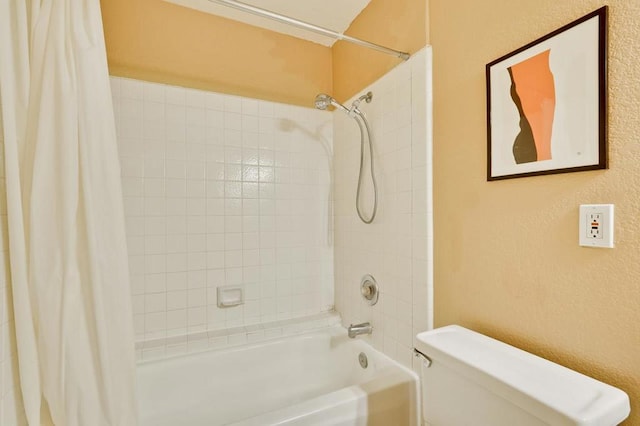 bathroom featuring shower / bath combo and toilet