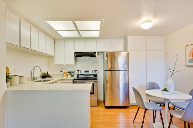 kitchen with white cabinets, appliances with stainless steel finishes, sink, and exhaust hood