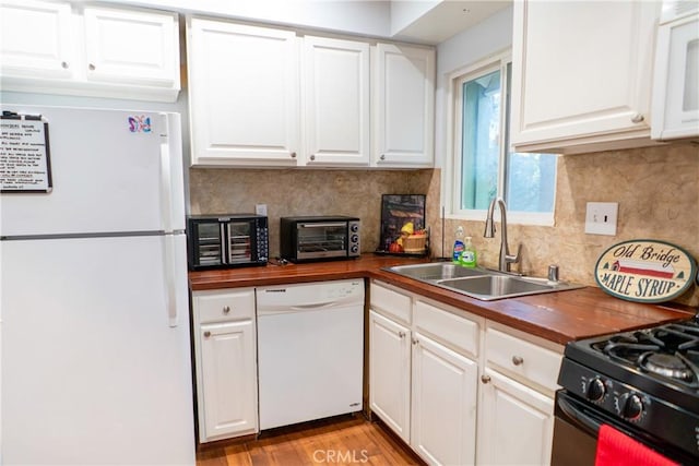 kitchen featuring white cabinetry, sink, backsplash, and white appliances