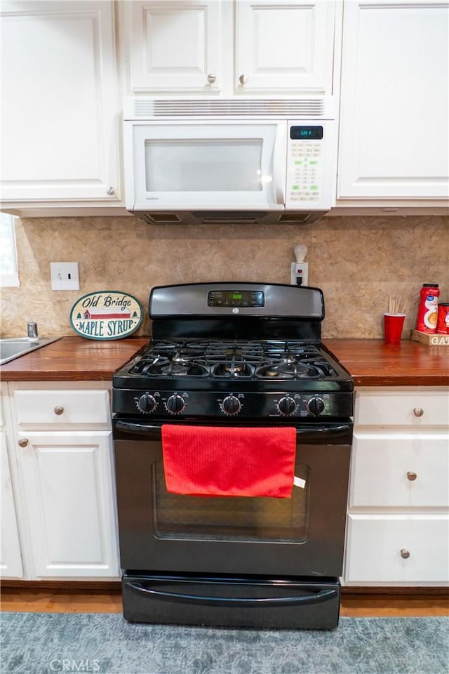 kitchen with tasteful backsplash, black range with gas cooktop, butcher block countertops, and white cabinets