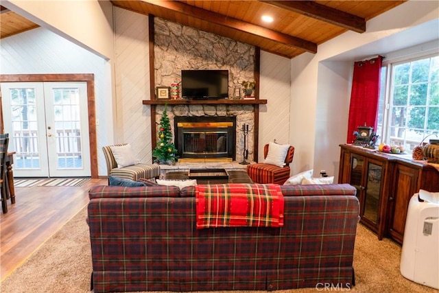 living room featuring wooden walls, a fireplace, vaulted ceiling with beams, wood ceiling, and french doors