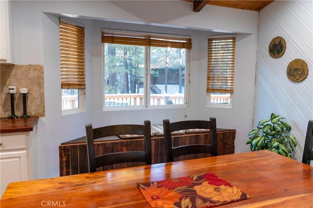 dining area with plenty of natural light and wooden walls